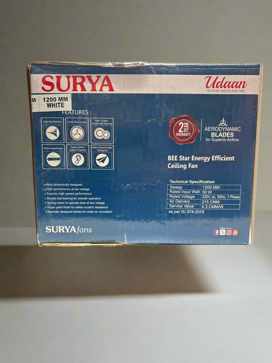 Surya ceiling fan box on a white surface with a blurred background